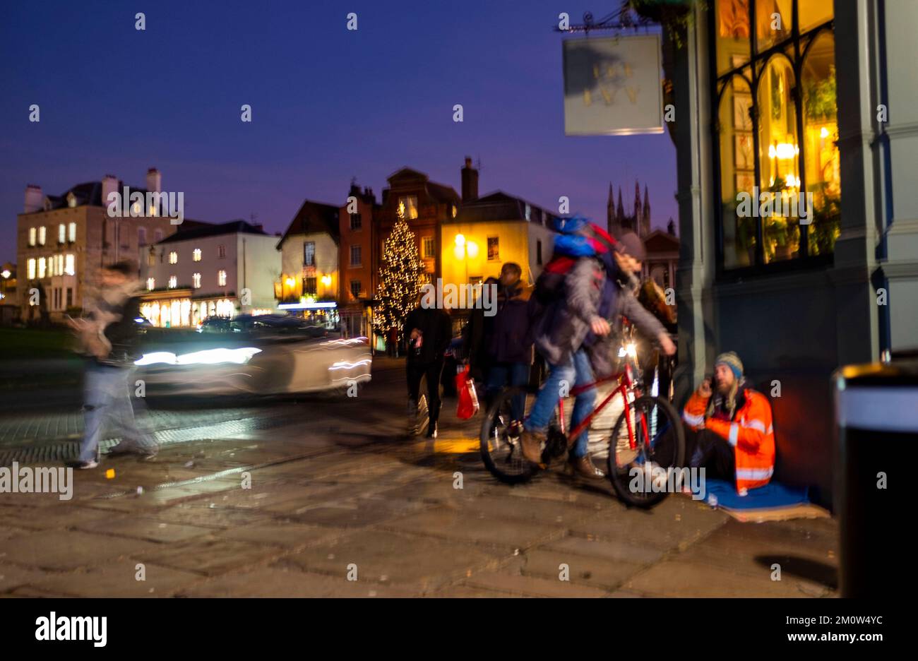 Un uomo senza casa che implora per le strade di Royal Windsor a Christmas Berkshire , Inghilterra , Regno Unito con effetto sfocato Credit Simon Dack Foto Stock
