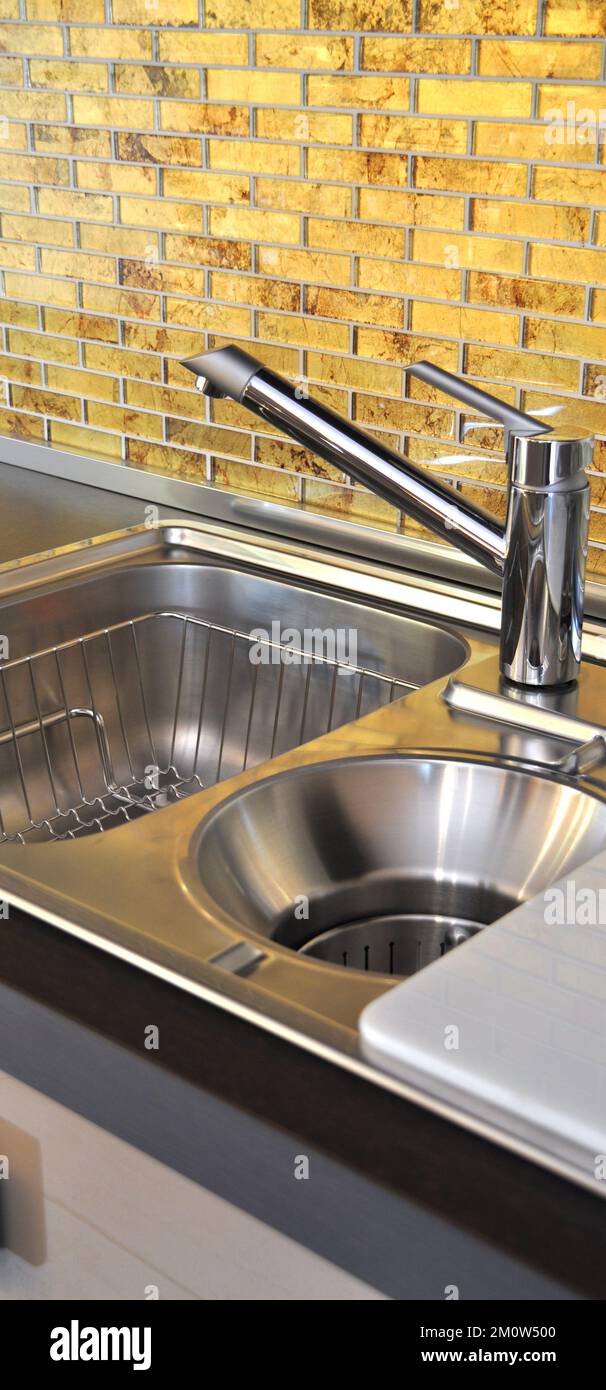 Interno di lussuosa cucina moderna e lavandino, rubinetto e scarico in acciaio inossidabile Foto Stock