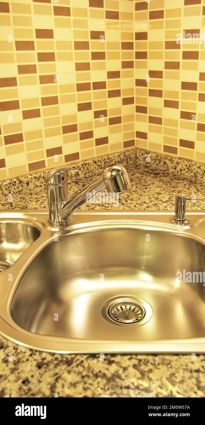 Interno di lussuosa cucina moderna e lavandino, rubinetto e scarico in acciaio inossidabile Foto Stock