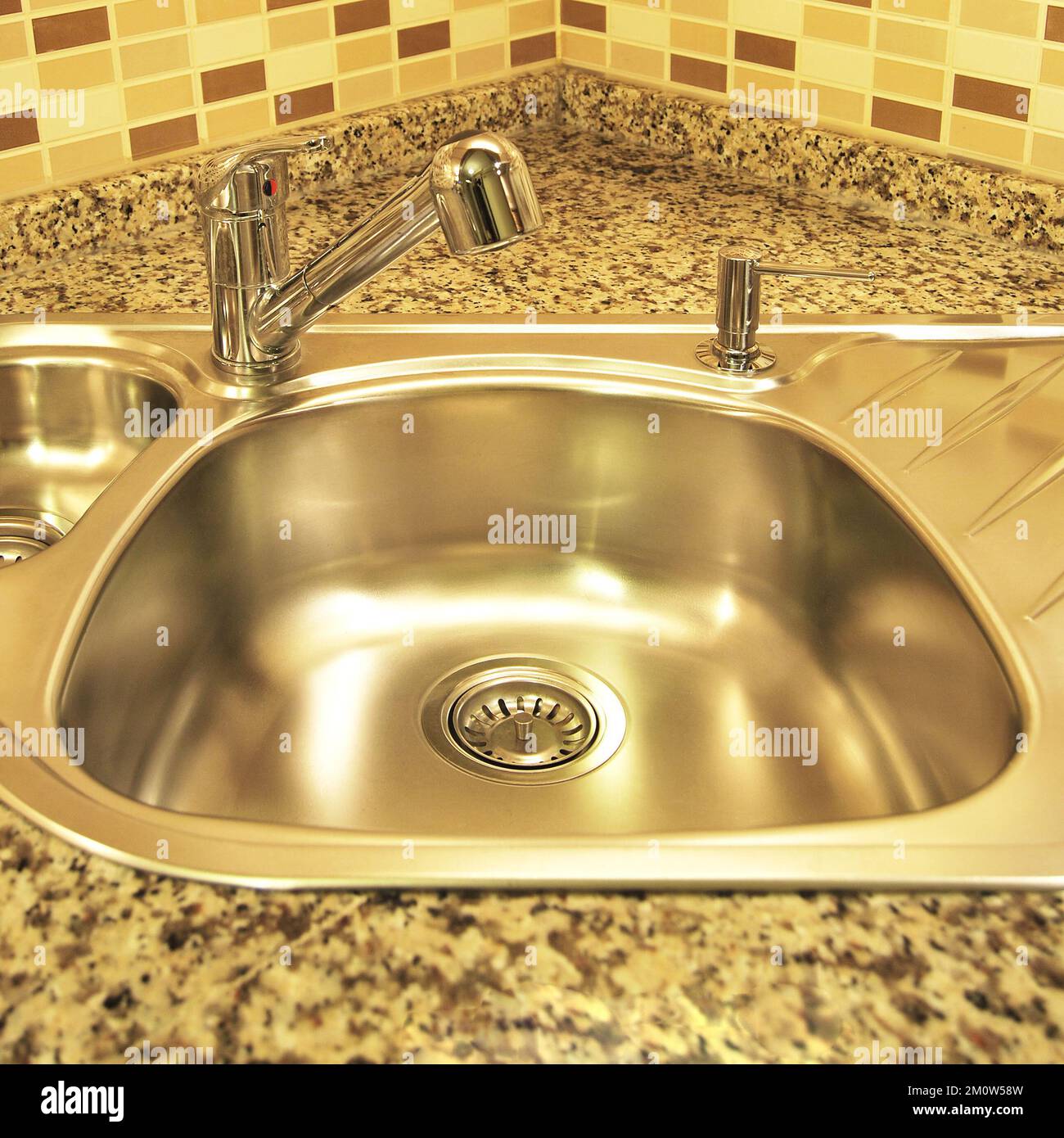 Interno di lussuosa cucina moderna e lavandino, rubinetto e scarico in acciaio inossidabile Foto Stock