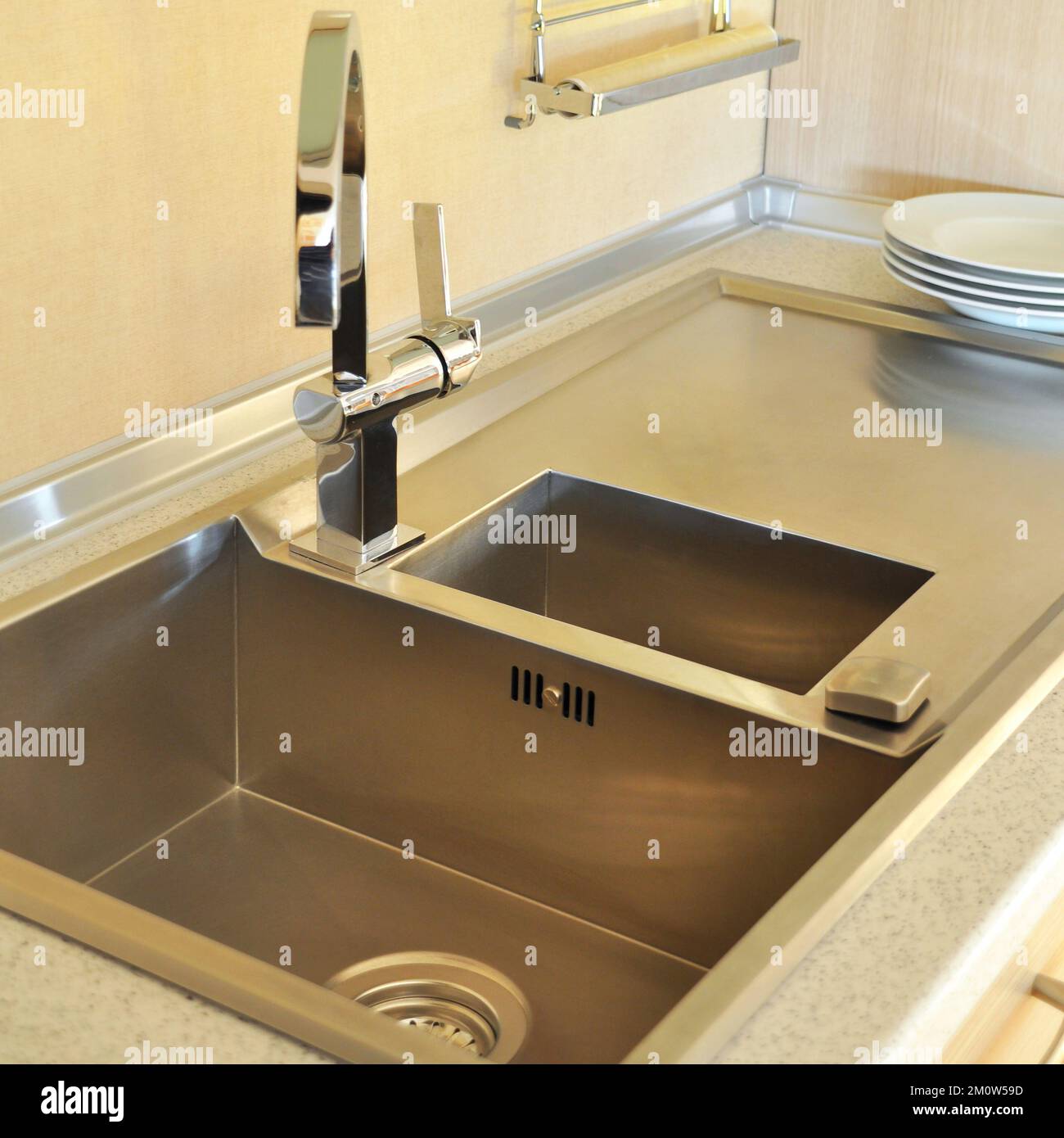 Interno di lussuosa cucina moderna e lavandino, rubinetto e scarico in acciaio inossidabile Foto Stock