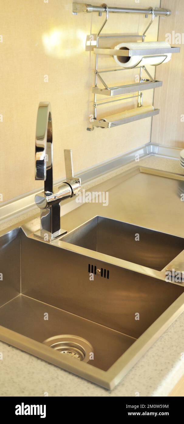 Interno di lussuosa cucina moderna e lavandino, rubinetto e scarico in acciaio inossidabile Foto Stock
