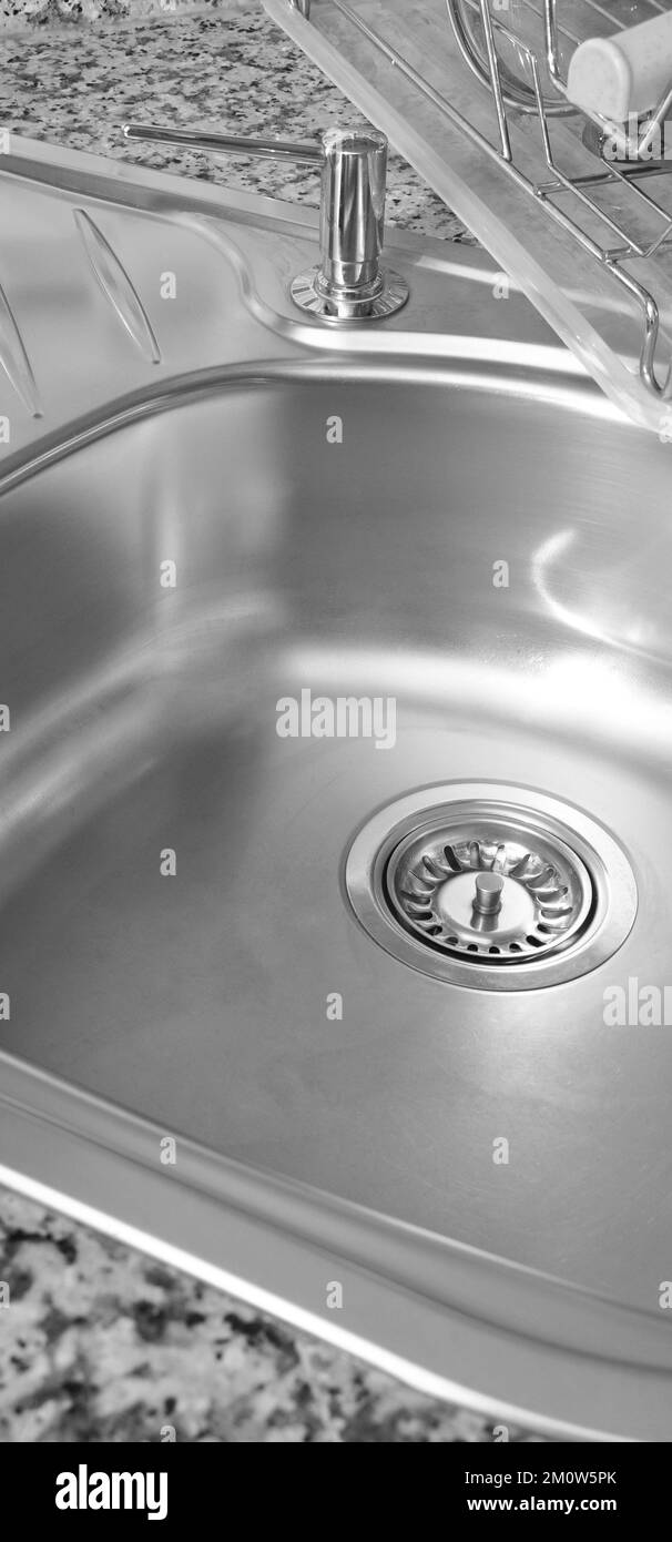 Interno di lussuosa cucina moderna e lavandino, rubinetto e scarico in acciaio inossidabile Foto Stock