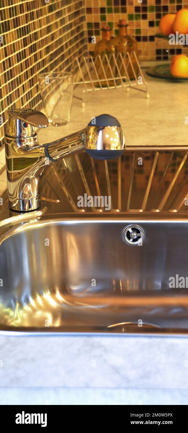 Interno di lussuosa cucina moderna e lavandino, rubinetto e scarico in acciaio inossidabile Foto Stock