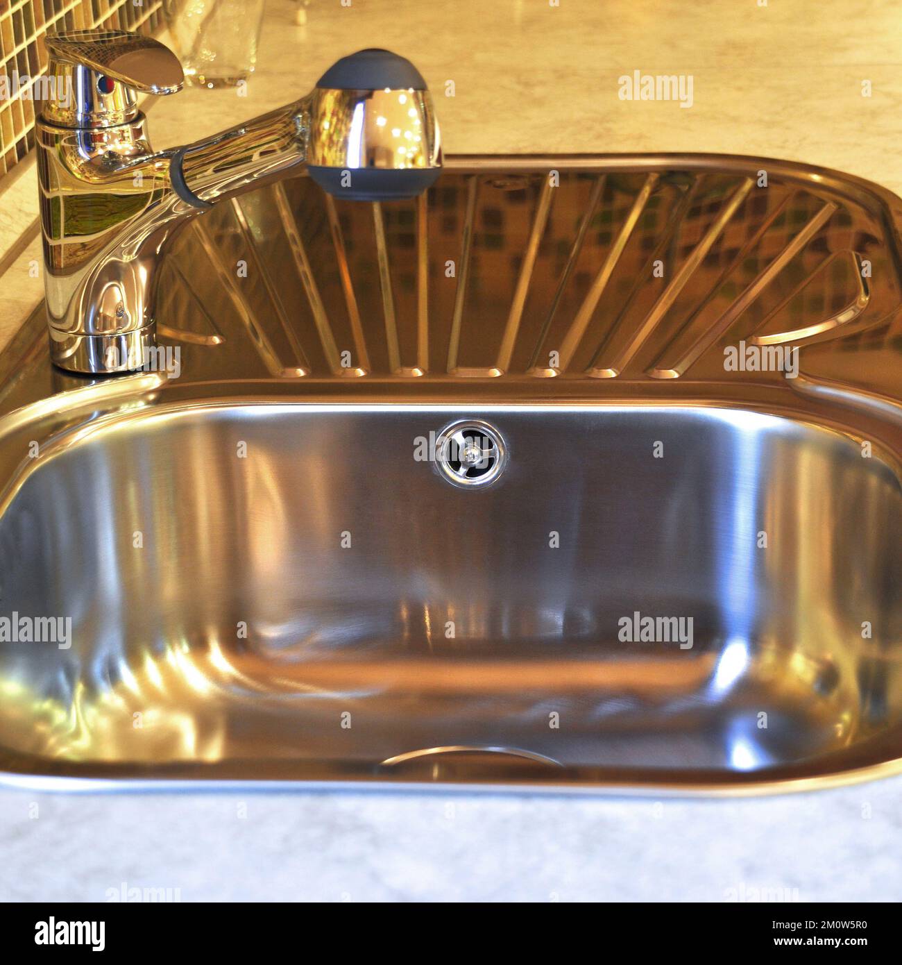 Interno di lussuosa cucina moderna e lavandino, rubinetto e scarico in acciaio inossidabile Foto Stock