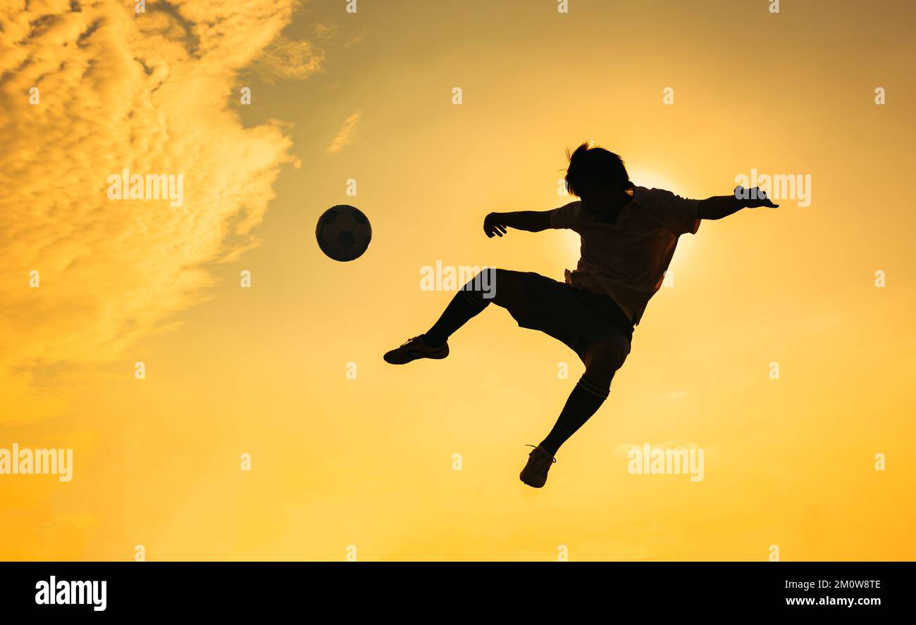 Silhouette sport d'azione all'aperto dei giocatori di calcio sul cielo tramonto. Atleta uomo jumping calcio palla per sfondo torneo di coppa del mondo. Foto Stock