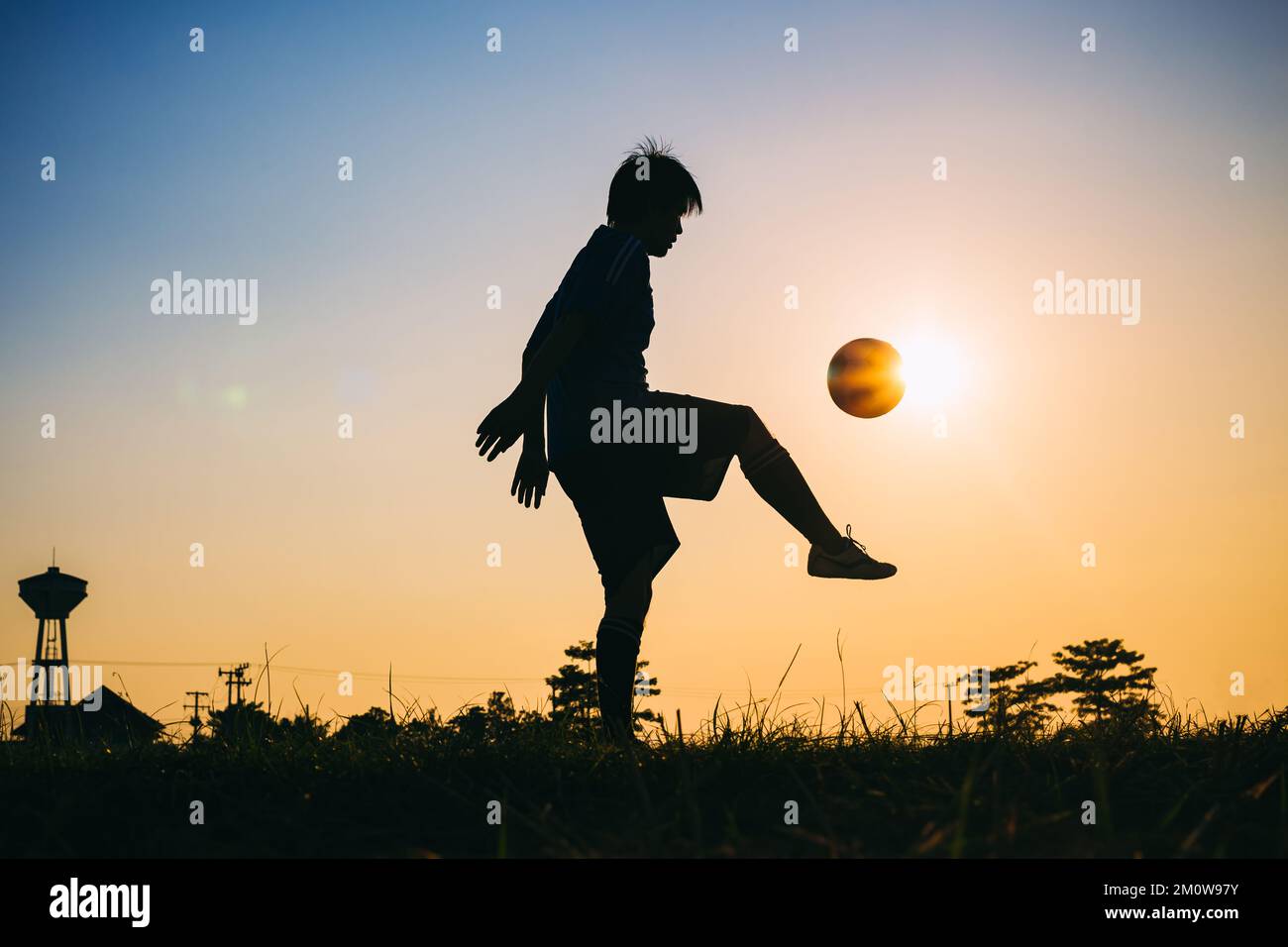 Silhouette sport d'azione all'aperto dei giocatori di calcio sul cielo tramonto. Atleta uomo jumping calcio palla per sfondo torneo di coppa del mondo. Foto Stock
