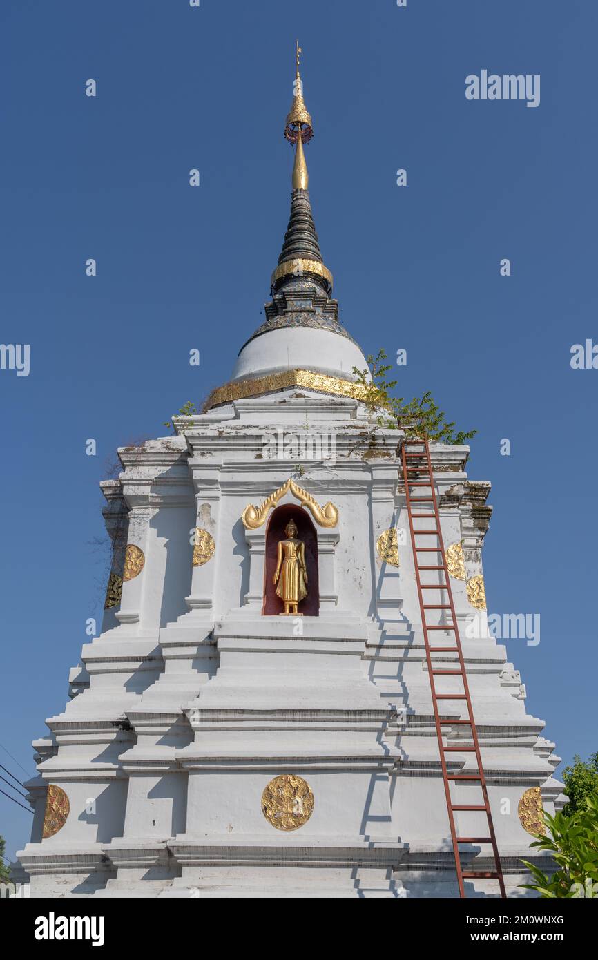 Vista panoramica dell'antico stupa bianco o chedi con statua del Buddha in piedi in nicchia presso lo storico tempio buddista Wat Chai Sri Phum, Chiang mai, Thailandia Foto Stock