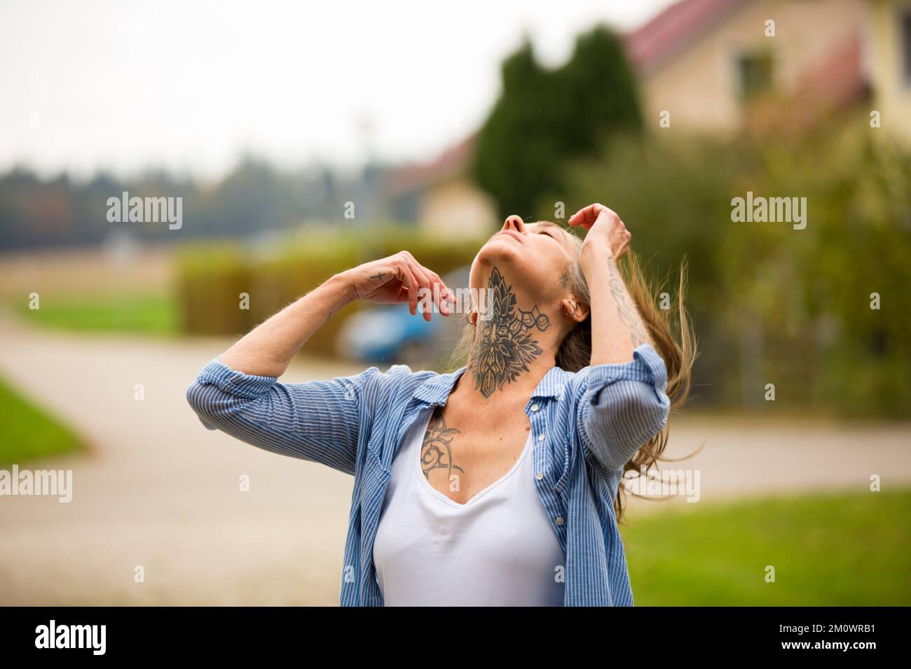 Modello femminile bst ager getta indietro i capelli in modo da poter vedere il suo collo Tattoo. Frau im besten Alter wirft die Haare Zurück, uomo sieht ihr Halstattoo. 50+ Foto Stock