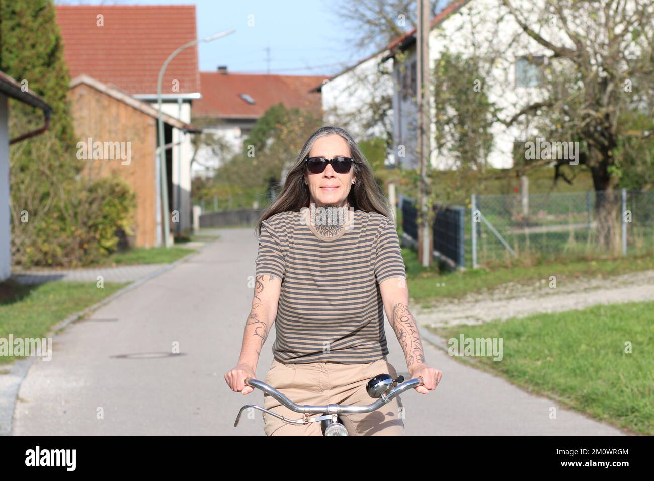 Migliore Ager femmina modello 50 Plus con invecchiamento bicicletta migliore. Frau 50 Jahre, sitzt auf einem Fahrrad und hält sich fit. 50 Plus, Tattoo, sportlich, Sport Foto Stock