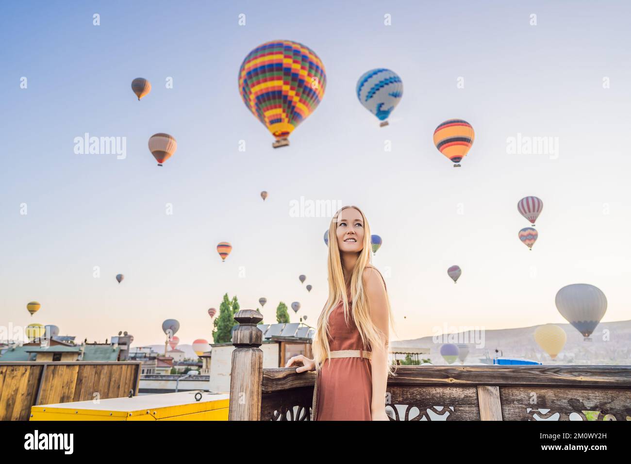 Donna turistica che guarda mongolfiere in Cappadocia, Turchia. Buon viaggio in Turchia concetto. Donna in cima a una montagna che gode di una vista meravigliosa Foto Stock