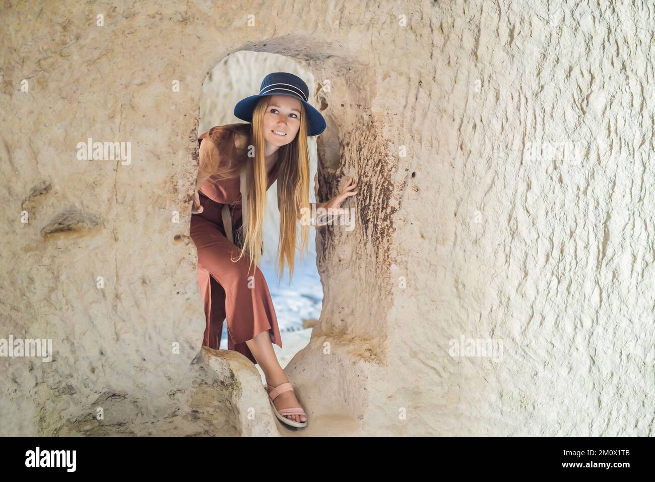 Giovane donna che esplora la valle con formazioni rocciose e grotte delle fate vicino a Goreme in Cappadocia Turchia Foto Stock