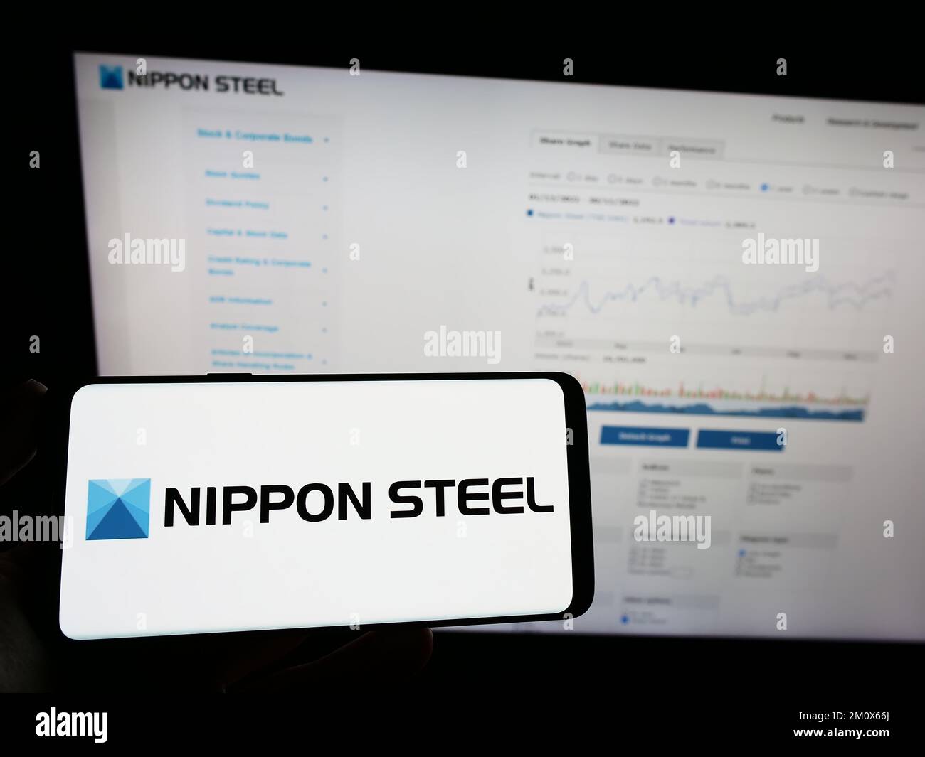 Persona che tiene un telefono cellulare con il logo della società giapponese Nippon Steel Corporation sullo schermo davanti alla pagina Web. Messa a fuoco sul display del telefono. Foto Stock