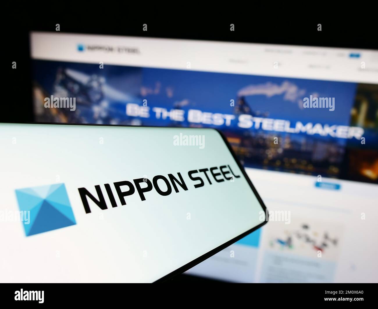 Telefono cellulare con il logo della società giapponese Nippon Steel Corporation sullo schermo di fronte al sito web aziendale. Messa a fuoco al centro del display del telefono. Foto Stock
