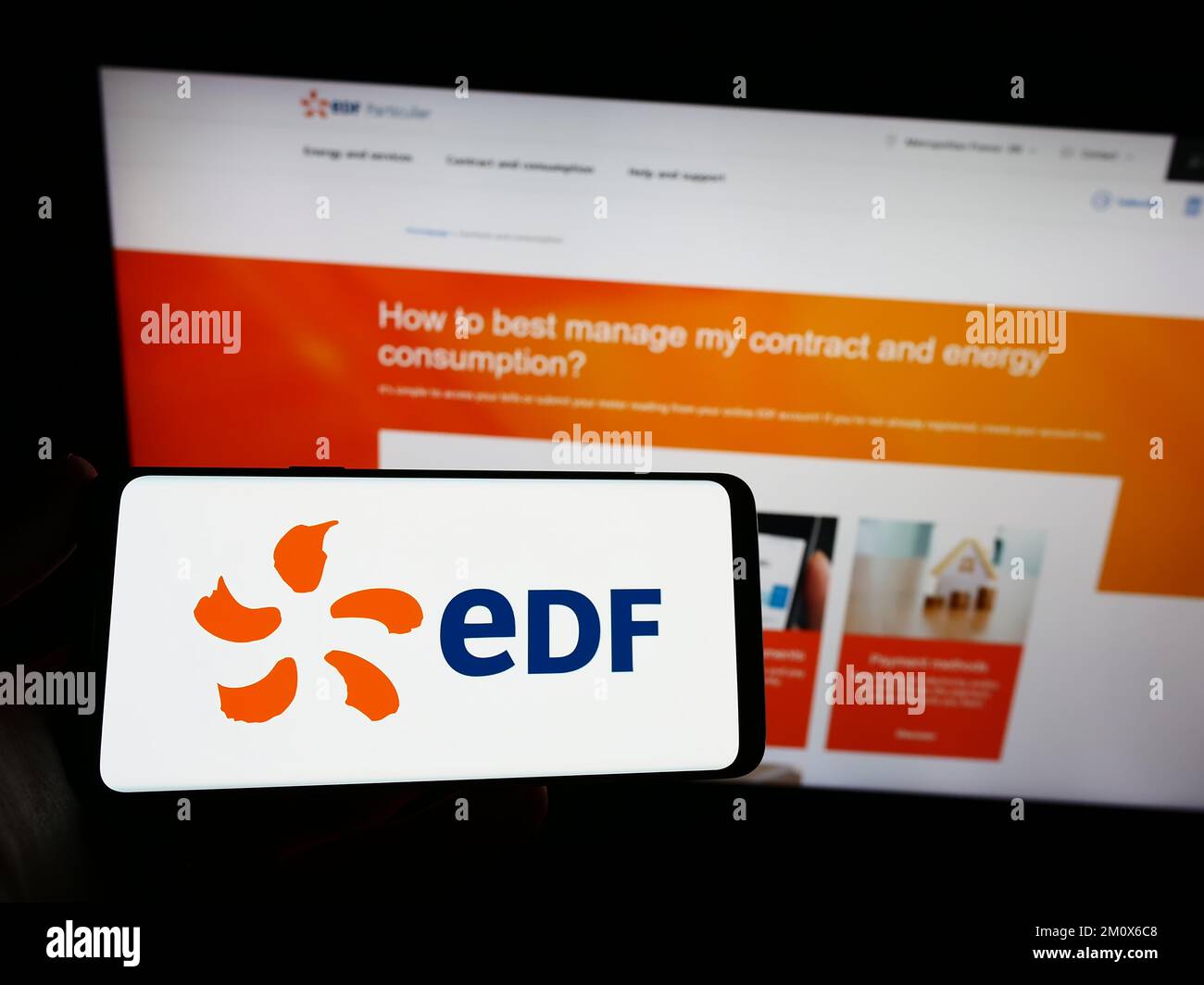 Persona che detiene uno smartphone con il logo della società energetica Electricite de France S.A. (EDF) sullo schermo davanti al sito web. Messa a fuoco sul display del telefono. Foto Stock