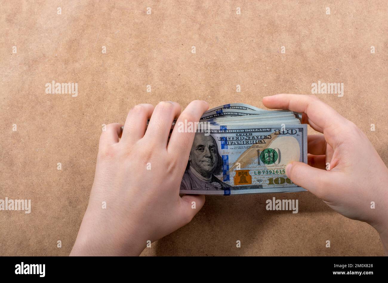 Mano che tiene le banconote del dollaro americano isolate su fondo di legno Foto Stock