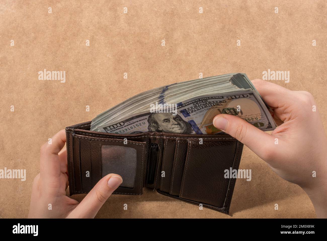 Mano che tiene le banconote del dollaro americano isolate su fondo di legno Foto Stock