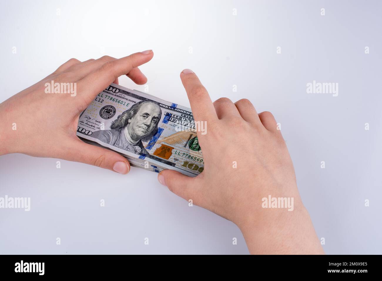 Mano umana tenendo dollaro americano Bill come denaro isolato su bianco Foto Stock