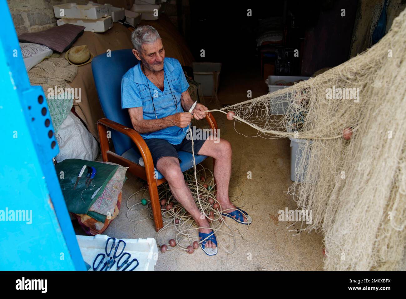 Vecchio pescatore che ripara reti, Trani, Puglia, Italia, Trani, Puglia, Italia, Europa Foto Stock