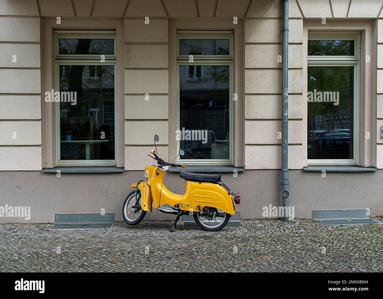 Scooter a motore giallo DDR Schwalbe di fronte alla facciata di una casa a Berlino, Berlino, Germania, Europa Foto Stock