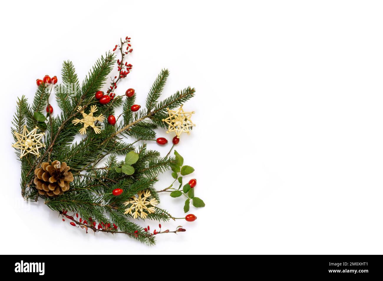 Angolo natalizio floreale naturale - decorazione rustica di abete rosso verde, rametti di barberry e frutti di rosa selvaggi con stelle di paglia, giacimento piatto, spazio copia Foto Stock