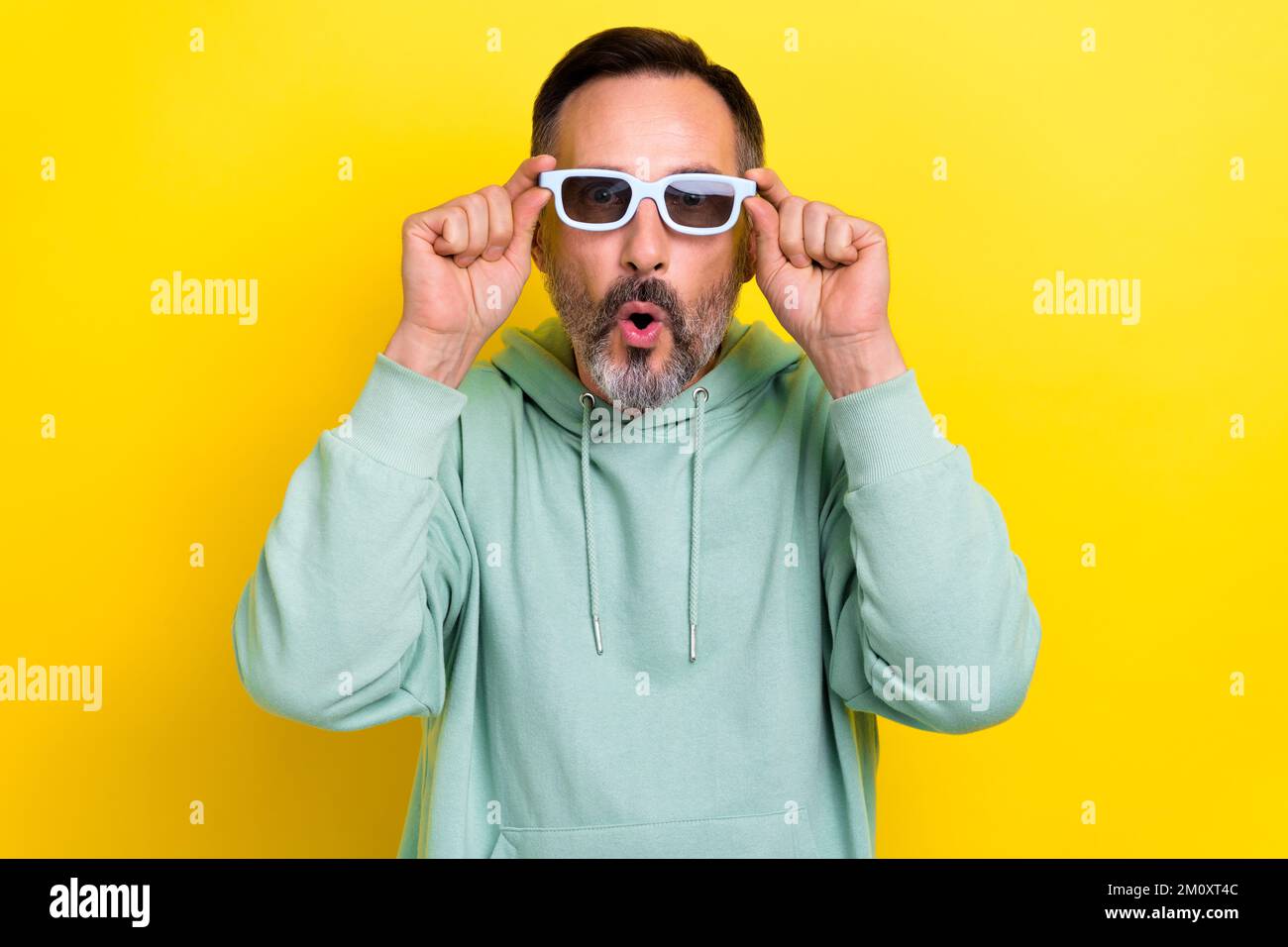 Foto di età matura grigio setole barba uomo indossare maglione cachi pouted labbra scioccato indossare 3D occhiali effetti visivi isolati su sfondo giallo Foto Stock