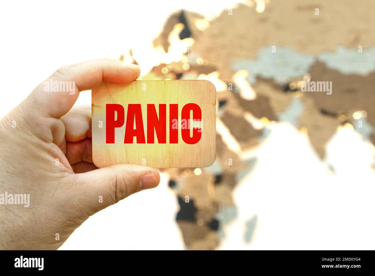 Medicina e concetto di salute. Sullo sfondo della mappa del mondo, un uomo tiene un segno con l'iscrizione - PANICO Foto Stock
