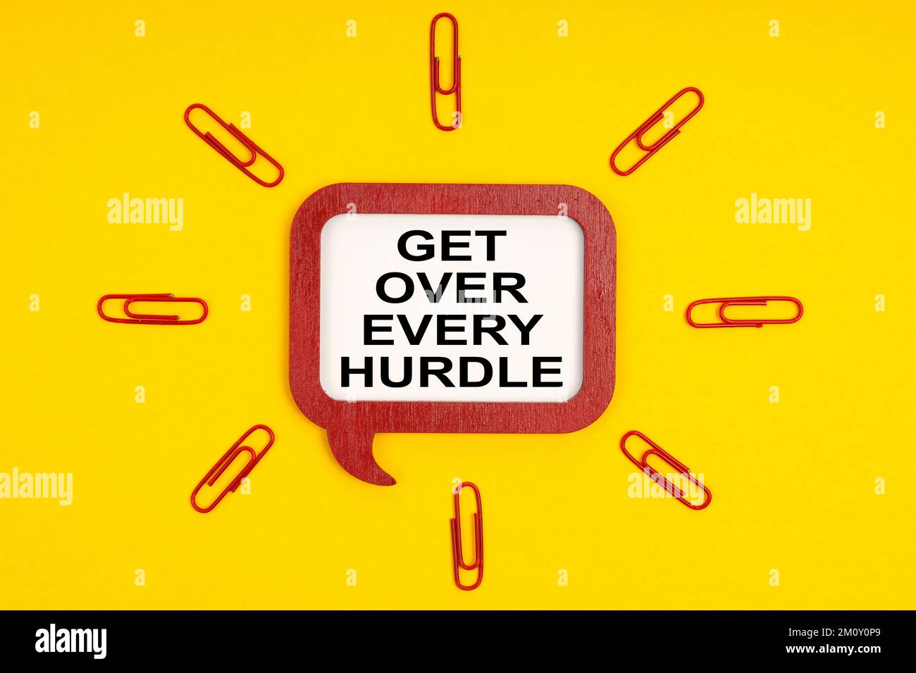 Concetto di business e di istruzione. Su uno sfondo giallo, graffette di carta e una placca mentale con l'iscrizione - superare ogni ostacolo Foto Stock