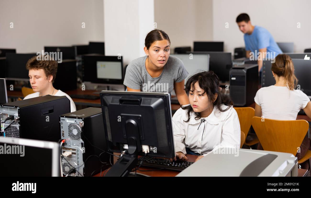 Insegnante e ragazza adolescente che studia informatica Foto Stock