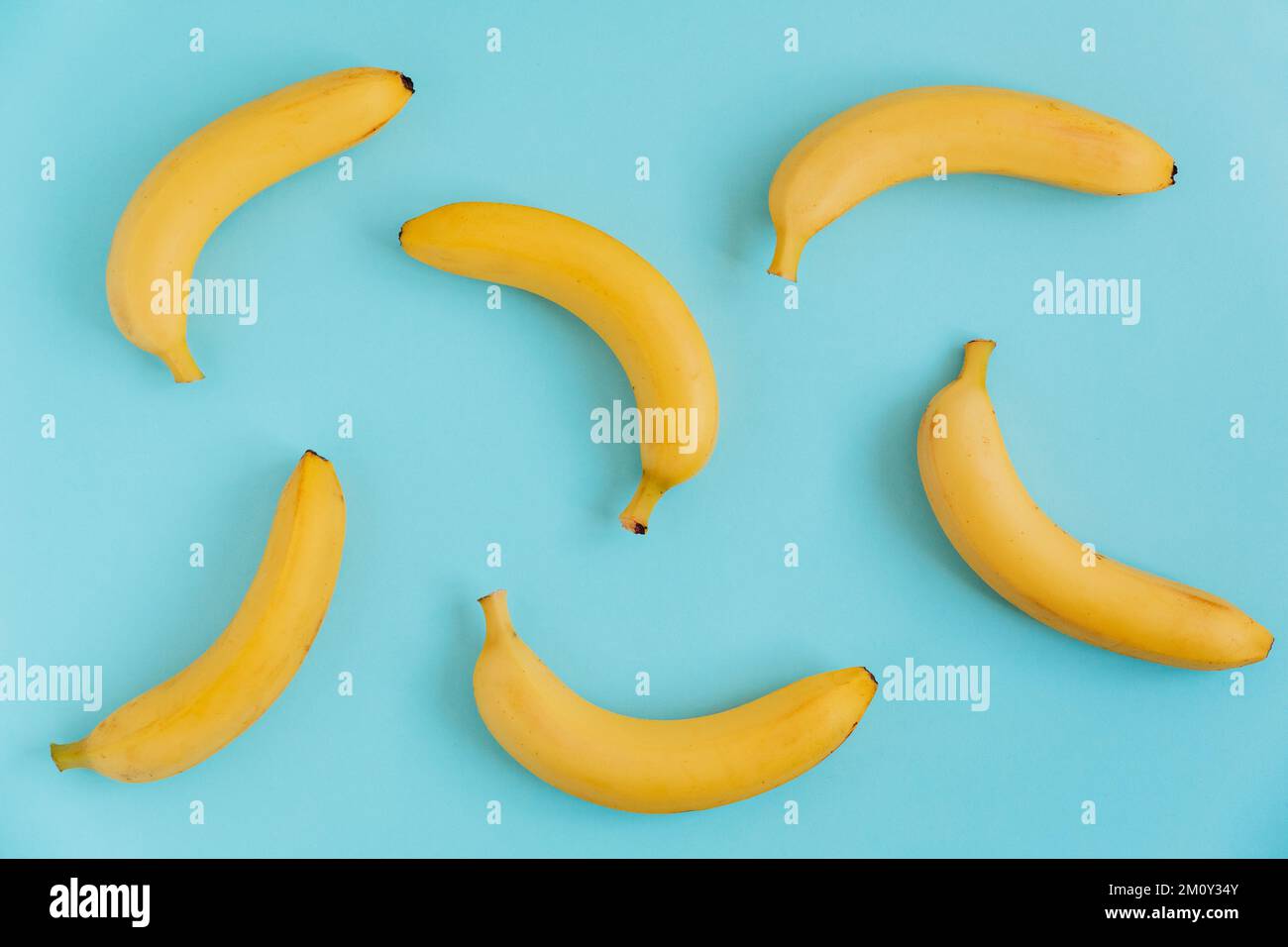 Banane fresche su sfondo blu. Giacitura piatta. Fondo di frutta. Modello di cibo Foto Stock