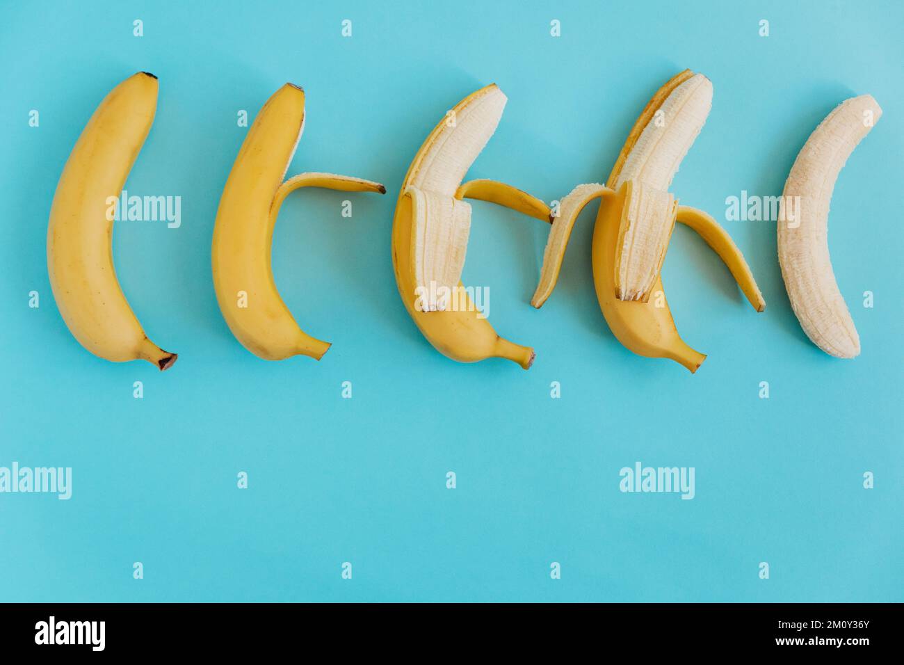 Banane fresche su sfondo blu. Giacitura piatta. Frutta sfondo. Colorato modello di frutta. Spazio per il testo Foto Stock