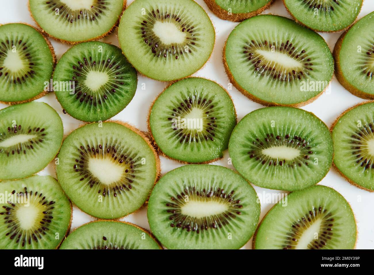Modello fruttato di kiwi e fette su fondo bianco. Concetto di cibo. Piano di giacitura, vista dall'alto, vista ravvicinata Foto Stock