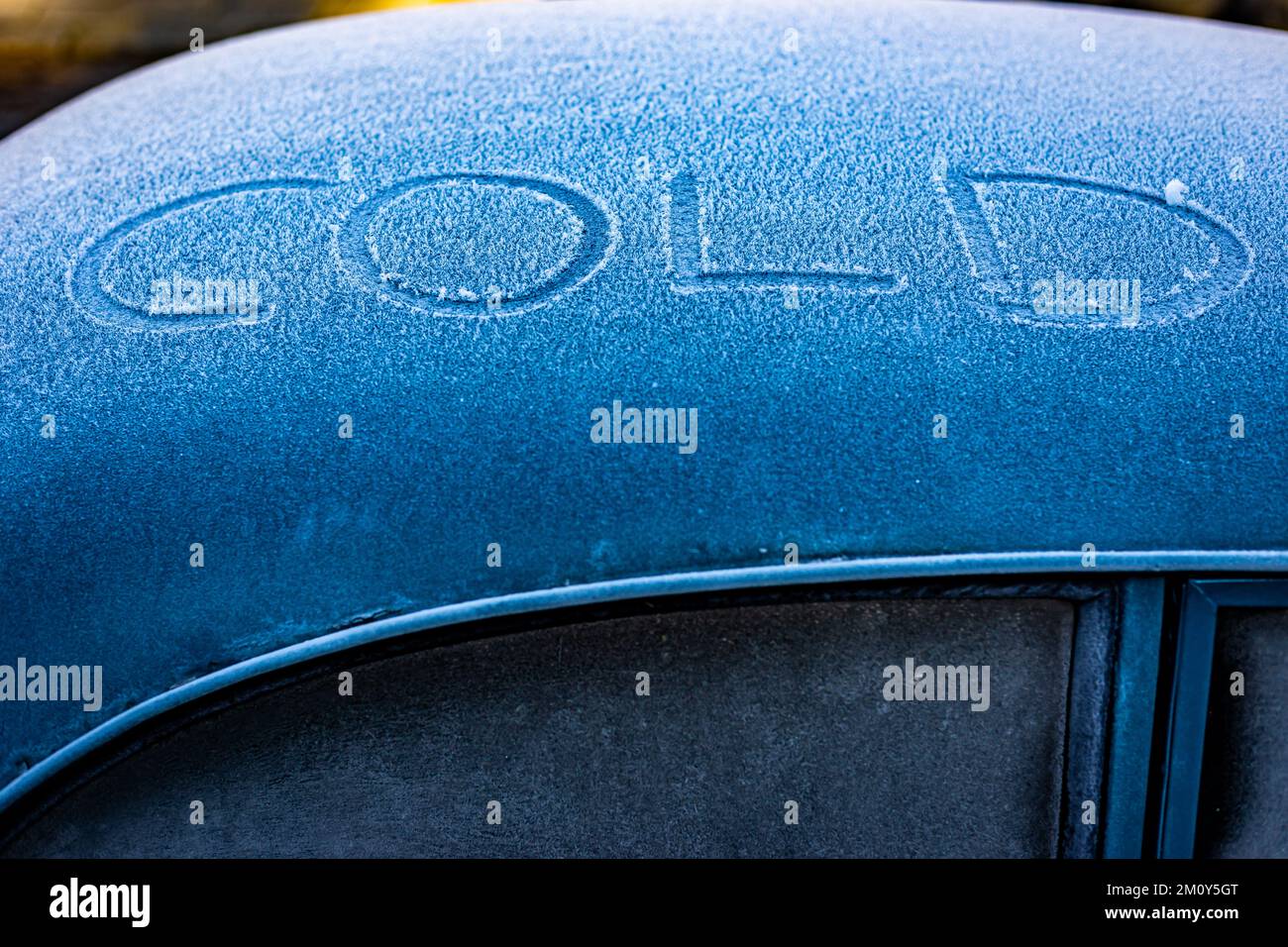 Segno freddo scritto sulla parte superiore di una vecchia Austin car.A scena invernale dove le temperature sono al punto di congelamento e amaramente freddo.il colore blu aggiunge dramma Foto Stock