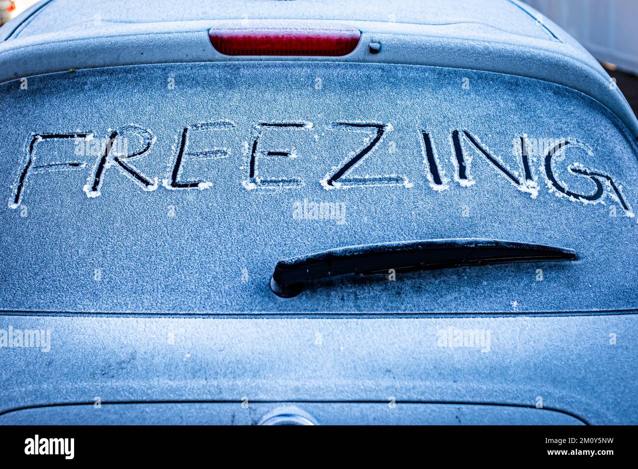 Auto parcheggiata durante la notte con segno DI CONGELAMENTO scritto sul finestrino posteriore.A concetto di FREDDO, immagine commerciale per prodotti auto e servizi di guasto ! Foto Stock