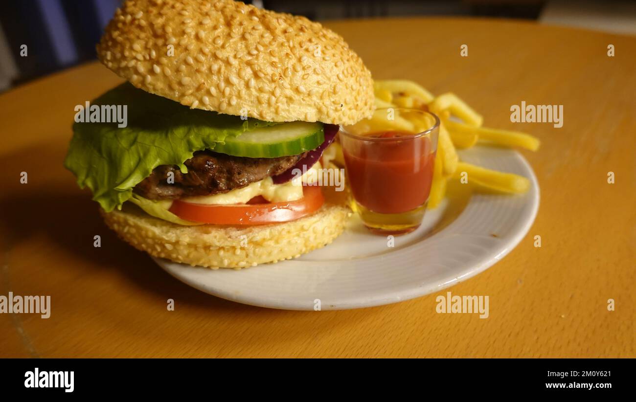 il tipico fast food un hamburger con patatine fritte Foto Stock