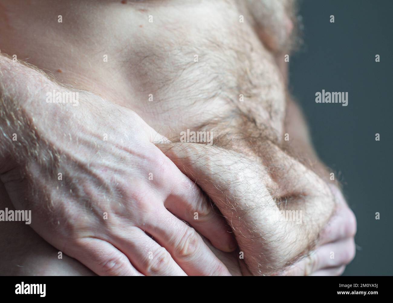 Dopo che il peso perde la pelle da vicino, uomo in forma che tiene la pelle ciao, i peli del corpo, il grasso corporeo, la lotta alla dieta Foto Stock
