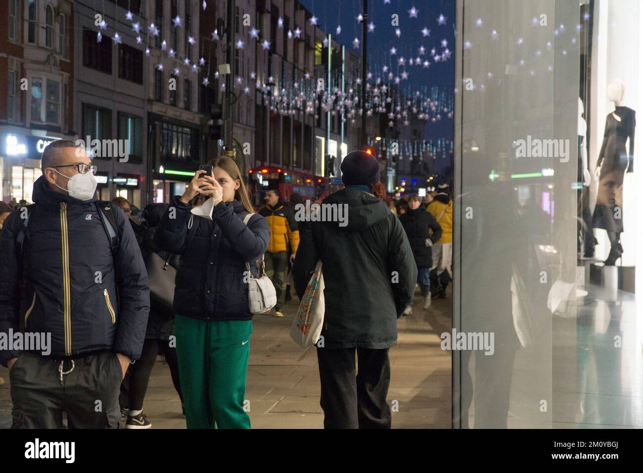 Londra, Regno Unito, 8 dicembre 2022: Le luci natalizie donano luccichezza al cielo del tramonto al tramonto su Oxford Street, nel West End. Gli acquirenti affollano le strade nonostante le preoccupazioni per la fiducia dei consumatori durante il costo della crisi. Anna Watson/Alamy Live News Foto Stock