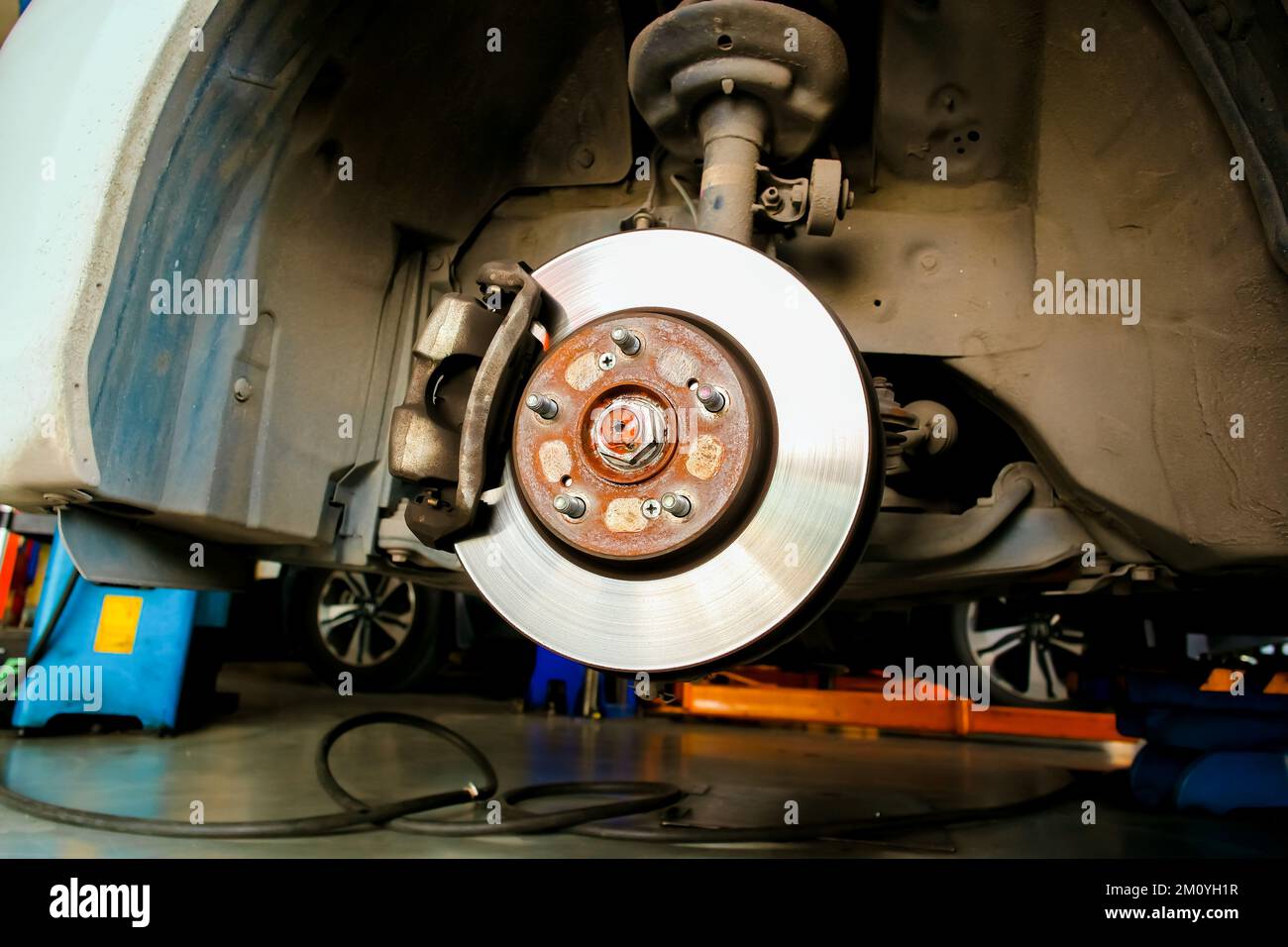 Freni a disco anteriori e pinze senza ruote nel garage di riparazione auto Foto Stock