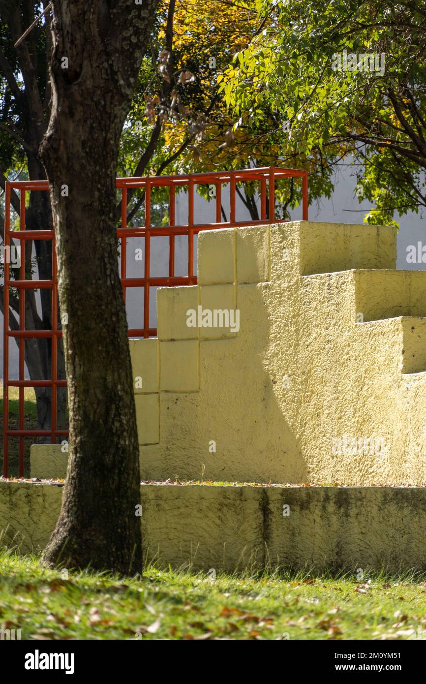 Colorato parco giochi per bambini attività nel parco pubblico circondato da alberi verdi al tramonto Foto Stock