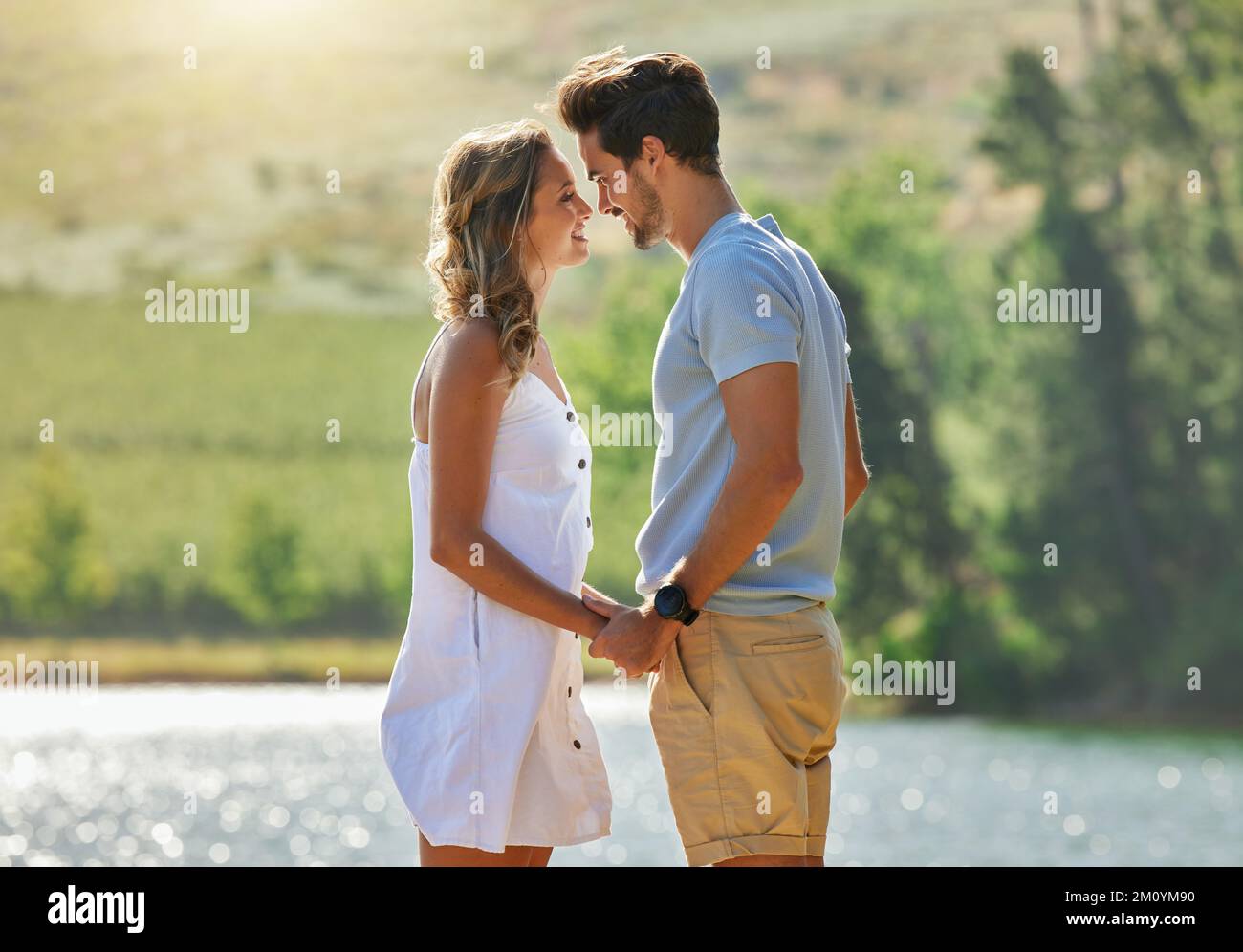 Youre mio per sempre. una giovane coppia che si unisce mentre si trova su un molo in un lago. Foto Stock