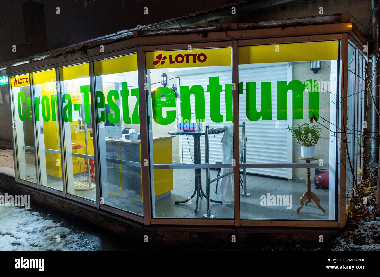 09 dicembre 2022, Meclemburgo-Pomerania occidentale, Lützow: Un cappotto bianco è appeso su un tavolo nel Corona Test Center chiuso e illuminato. Foto: Jens Büttner/dpa Foto Stock