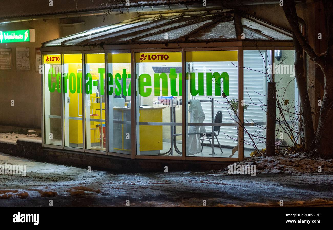 09 dicembre 2022, Meclemburgo-Pomerania occidentale, Lützow: Un cappotto bianco è appeso su un tavolo nel Corona Test Center chiuso e illuminato. Foto: Jens Büttner/dpa Foto Stock