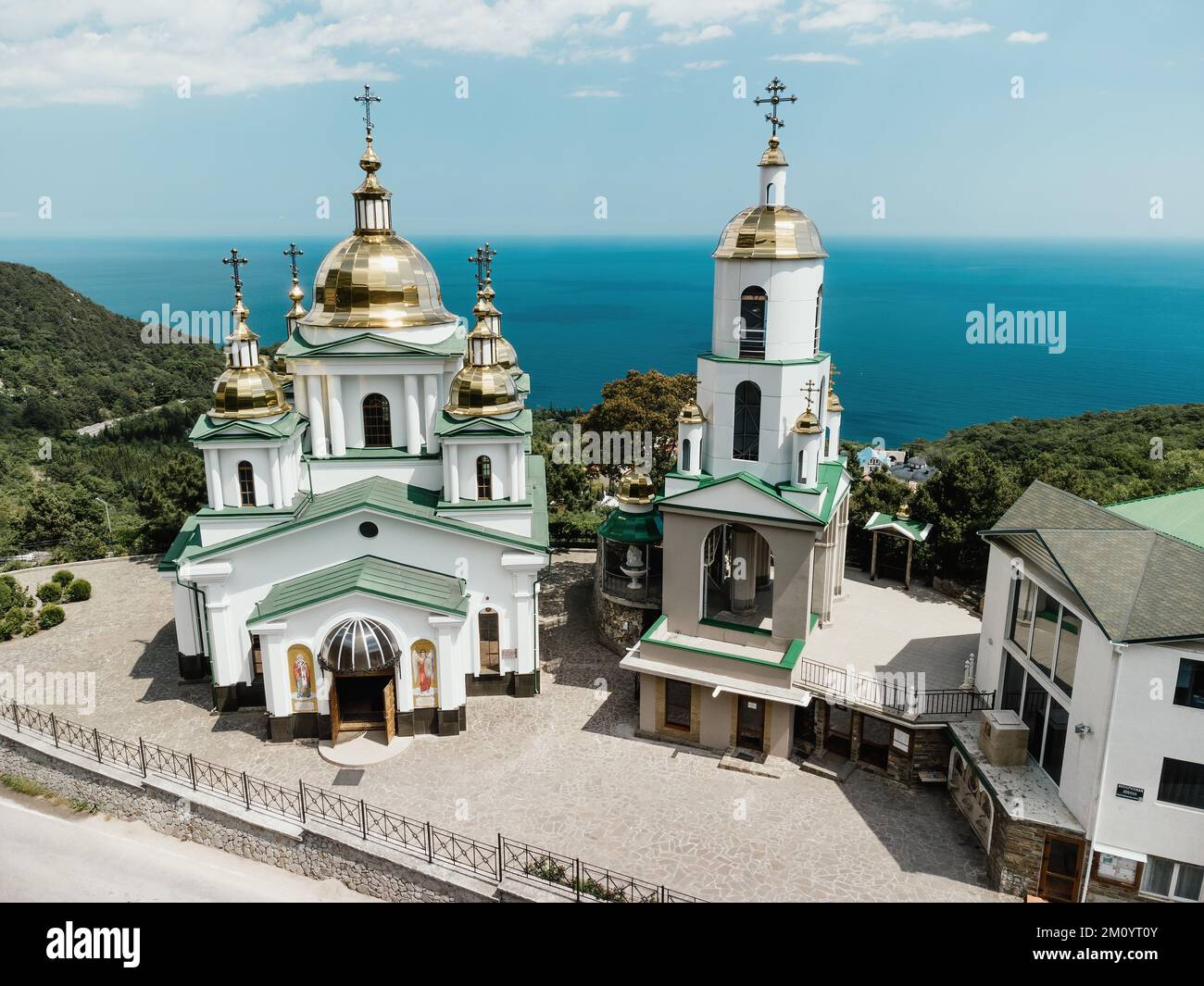Chiesa cristiana nelle montagne sopra il mare. Tempio del Santo Arcangelo Michele in Oreanda. La costa meridionale della Crimea. Vista aerea Foto Stock