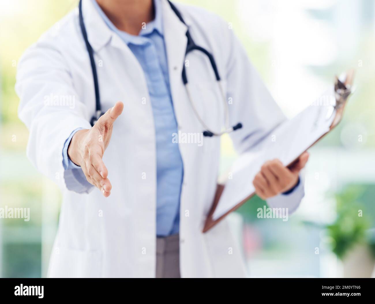 Non avete niente di cui preoccuparsi. Primo piano di un medico irriconoscibile che estende una stretta di mano in un ospedale. Foto Stock