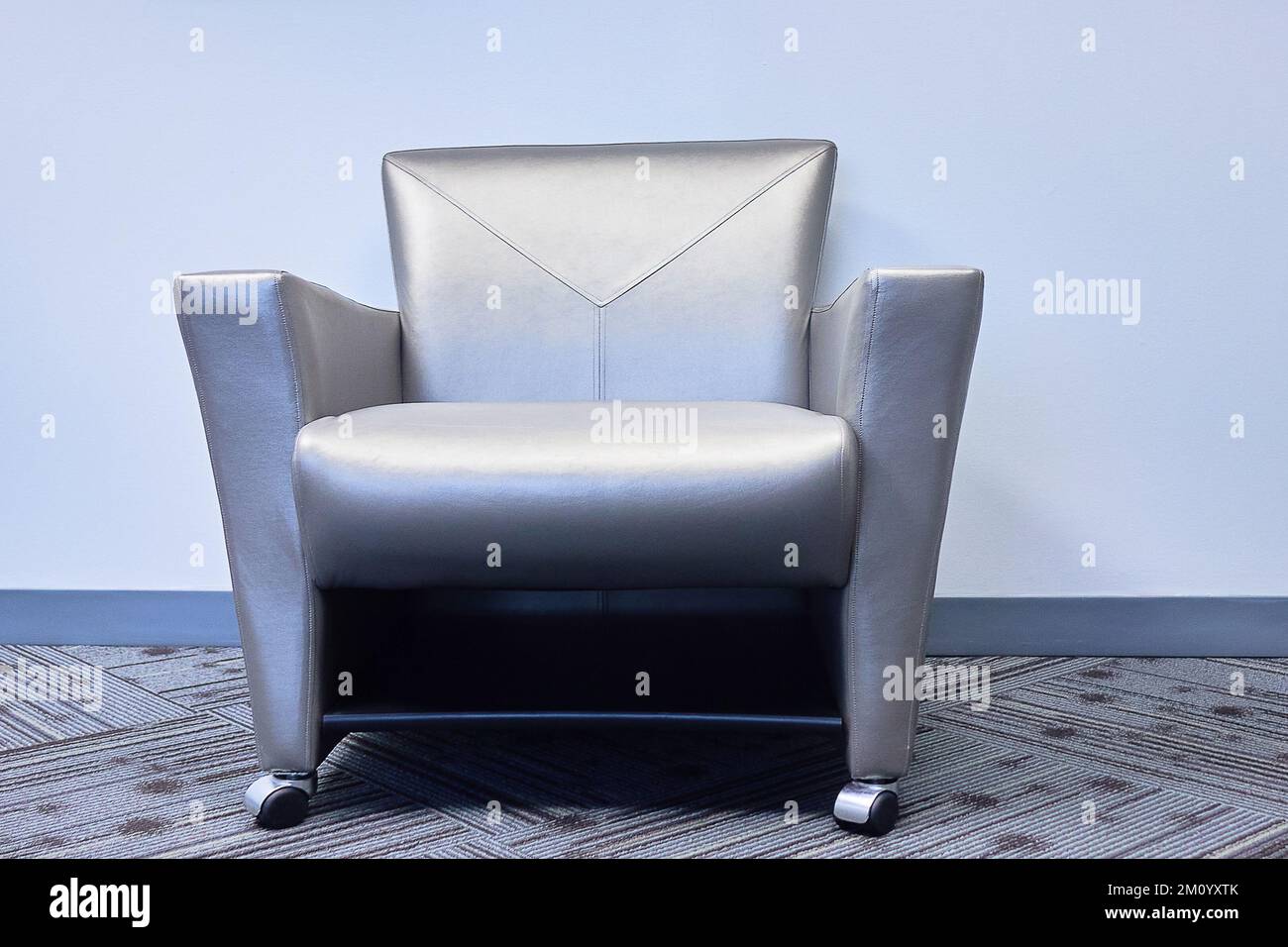sedia da ufficio grigia moquette sedia da parete grigia in pelle Foto Stock