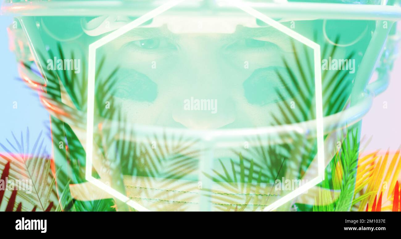 Primo piano del calciatore americano che indossa il casco con l'esagono illuminato e le piante colorate. Digital composite, viso, occhio, sport, competizione, illu Foto Stock