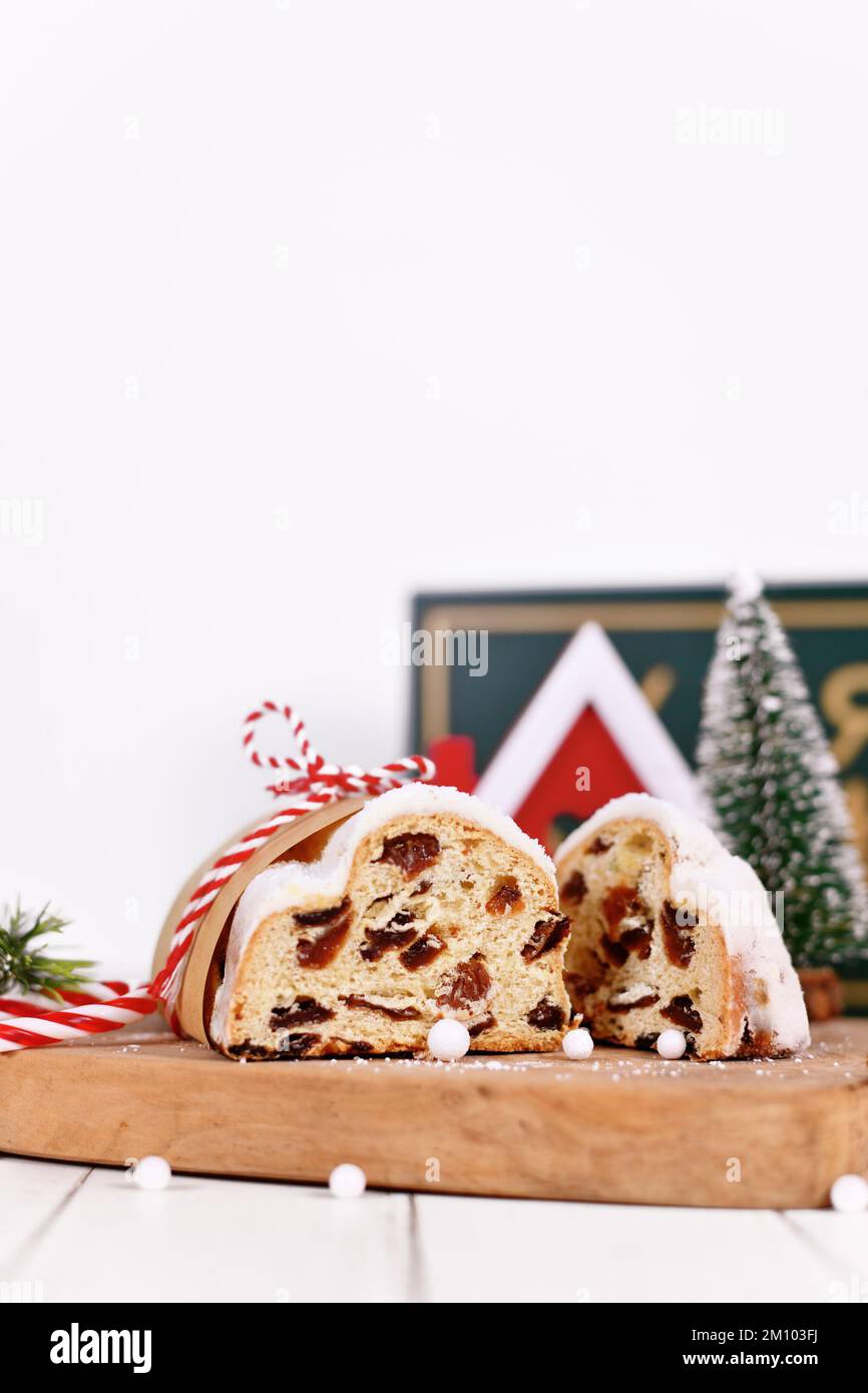 Tagliate la torta tedesca Stollen, un pane di frutta con noci, spezie e frutta secca con zucchero a velo tradizionalmente servito durante il periodo natalizio Foto Stock