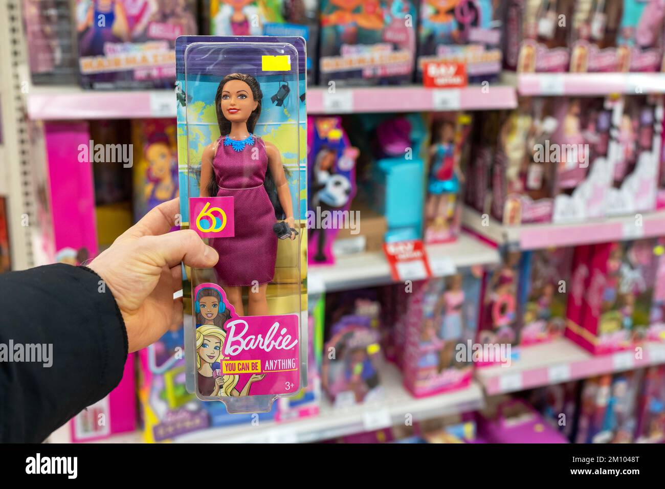 Barbie - una donna con 60s anni, un presentatore TV con microfono in mano. Barbie è una bambola di moda prodotta dalla società americana Mattel Foto Stock