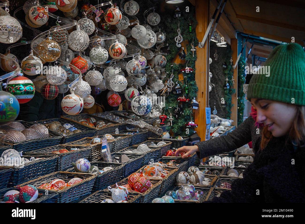 La gente sta scegliendo le decorazioni di Natale nel chiosco di mercato di Natale Foto Stock