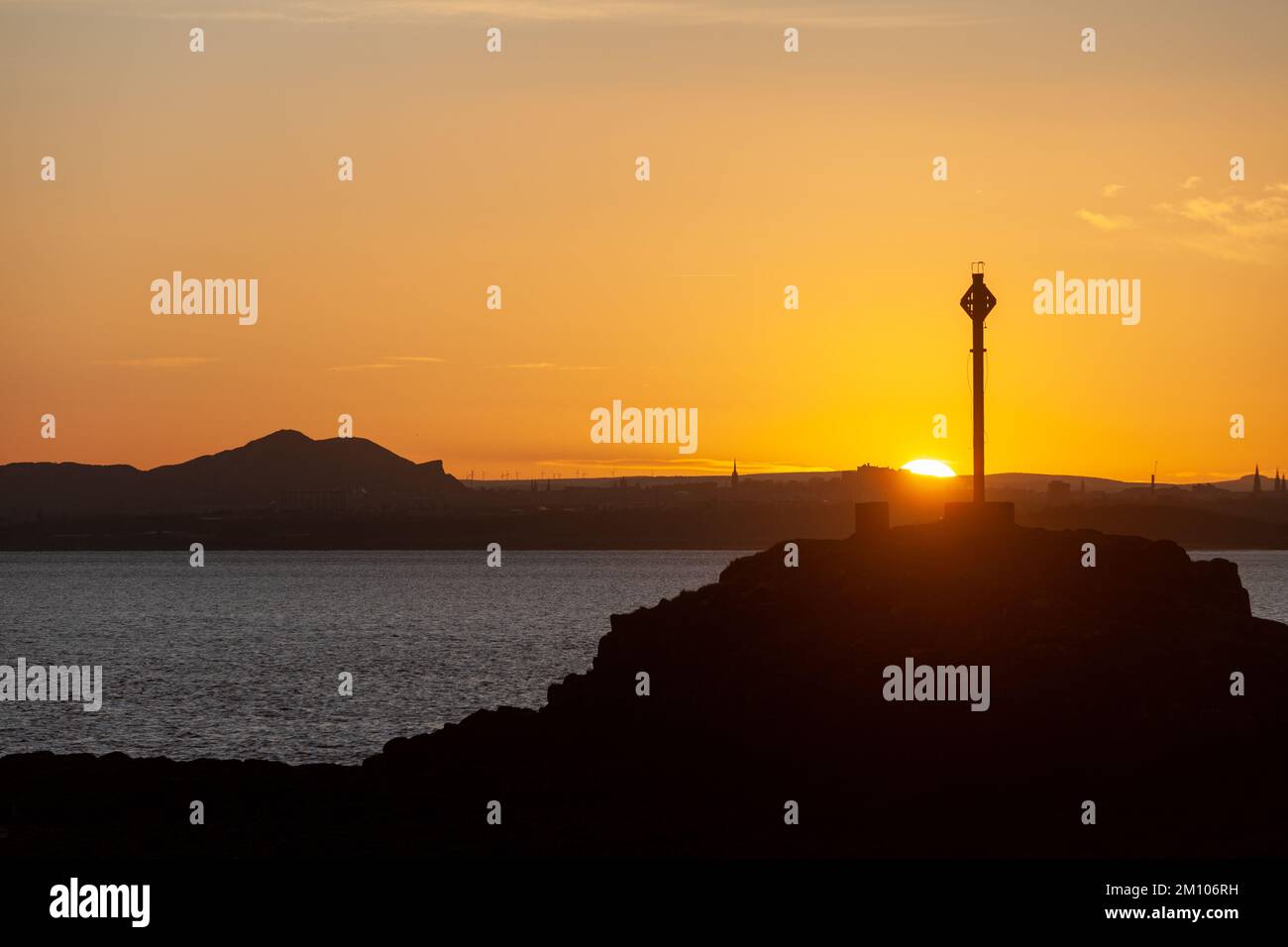 Dalgety Bay, Fife, Scozia. 09 dicembre 2022. Una giornata fredda in Scozia scaldata da un bellissimo tramonto sulla Arthur’s Seat di Edimburgo e su Downing Point a Dalgety Bay. © Richard Newton / Alamy Live News Foto Stock